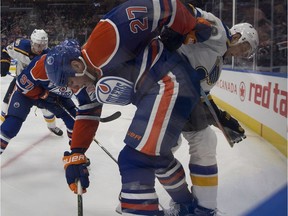 Edmonton Oilers forward Milan Lucic (27) hangs onto St. Louis Blues defenceman Jay Bouwmeester (19) during NHL action on Oct. 20, 2016, in Edmonton.