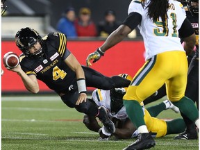 Hamilton Tiger-Cats quarterback Zach Collaros (4) makes a pass while being tackled by Edmonton Eskimos defensive tackle Almondo Sewell (90) during the first-half of CFL football action in Hamilton on Friday, October 28, 2016.