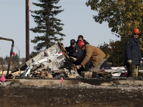 Investigators search rubble at the scene of a fatal fire at the Bashaw Motor Inn in Bashaw on Tuesday, Oct. 11, 2016.