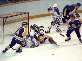 It was sheer terror in the Los Angeles crease as the Oilers stuffed the Kings' stockings with nothing but goals. Kings' goalie Darren Eliot is forced to play puck with Dave Hunter on his back while Grant Ledyard (left) skates back to help. Bruce Edwards / Edmonton Journal file photo. December 20 1985