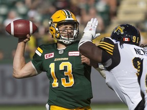 Edmonton Eskimos quarterback Mike Reilly (13) makes the throw against the Hamilton Tiger-Cats during first half CFL action in Edmonton, Alta., on Saturday July 23, 2016.
