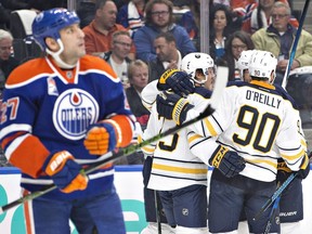 The Buffalo Sabres celebrates a goal as Edmonton Oilers' Milan Lucic (27) skates past during first period NHL action in Edmonton, Alta., on Sunday October 16, 2016.