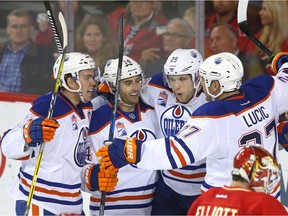 Oilers Connor McDavid, Jordan Eberle, Leon Draisaitl and Milan Lucic celebrate a third period goal in front of Flames goalie Brian Elliott during NHL action between the Edmonton Oilers and the host Calgary Flames on Oct. 14, 2016.