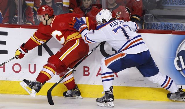 Edmonton Oilers' Oscar Klefbom, right, from Sweden, battles with Calgary Flames' Mikael Backlund, from Sweden, during third period NHL action in Calgary, Alta., Friday Oct. 14, 2016.