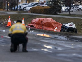 An Edmonton Police Service officer takes photographs as officers investigate a fatal collision on 97 Street at 160 Avenue in Edmonton, Alberta on Monday, October 24, 2016.