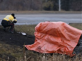 An Edmonton Police Service officer takes photographs as officers investigate a fatal collision on 97 Street at 160 Avenue in Edmonton on Oct. 24, 2016.