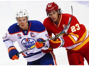 Edmonton Oilers Connor McDavid battles for the puck against Sean Monahan of the Calgary Flames during NHL hockey in Calgary, Alta., on Friday, October 14, 2016. AL CHAREST/POSTMEDIA