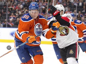 Ottawa Senators' Ryan Dzingel (18) and Edmonton Oilers' Jesse Puljujarvi (98) battle for the loose puck during third period NHL action in Edmonton, Alta., on Sunday October 30, 2016.