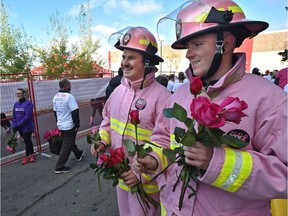 Spruce Grove firefighters Brett Dahl (right) and Mitch Balfour hand roses to survivors at the finish line during the Canadian Breast Cancer Foundation CIBC Run for the Cure in Edmonton Sunday, October 2, 2016.