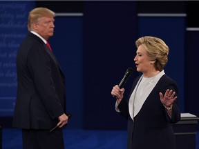 U.S. Democratic presidential candidate Hillary Clinton speaks as Republican presidential candidate Donald Trump listens during the second presidential debate at Washington University in St. Louis, Mo., on Oct. 9, 2016.