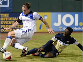 FC Edmonton captain Albert Watson, left, gets taken down by Jacksonville Armada FC forward Alhassane Keita in North American Soccer League play, Wednesday Sept 28, 2016 in Jacksonville, Florida.