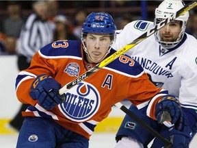 Ryan Nugent-Hopkins #93 of the Edmonton Oilers battles against Dan Hamhuis #2 of the Vancouver Canucks on April 6, 2016 at Rexall Place in Edmonton.