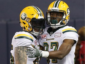 Edmonton Eskimos' Mike Miller (25) and Derel Walker (87) celebrate Walker's touchdown during the second half of CFL action against the Winnipeg Blue Bombers in Winnipeg Friday, September 30, 2016.