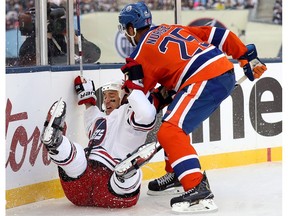 Winnipeg Jets' Shawn Matthias (16) is tripped up by Edmonton Oilers' Darnell Nurse (25) during second period action at the NHL Heritage Classic at Investors Group Field in Winnipeg, Sunday, October 23, 2016.