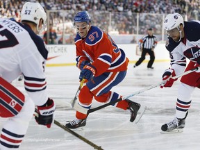 Edmonton Oilers' Connor McDavid (97) looks for the puck with Winnipeg Jets' Tyler Myers (57) and Blake Wheeler (26) during first period NHL Heritage Classic action in Winnipeg on Sunday, October 23, 2016.