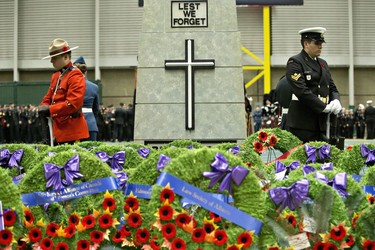 A member of the RCMP and a Navy officer stand guard at a cenotaph during a Remembrance Day ceremony in Edmonton on Friday November 11, 2016.