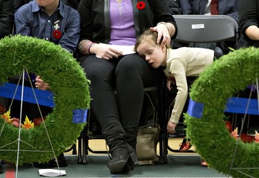 A young girl tuckers out and closes her eyes during a Remembrance Day ceremony in Edmonton on Friday November 11, 2016.