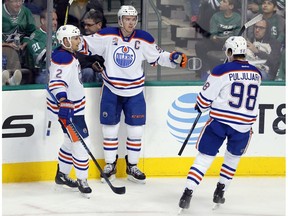 Edmonton Oilers' Andrej Sekera (2) and Jesse Puljujarvi (98) celebrate with Connor McDavid after McDavid scored in the third period against the Dallas Stars on Saturday, Nov. 19, 2016, in Dallas.