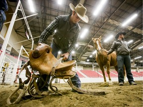 Clay Elliott preps a saddle bronc saddle at the Calgary Stampede Grounds on Dec. 19, 2014. They were promoting that year's Ultimate Cowboy Rodeo.