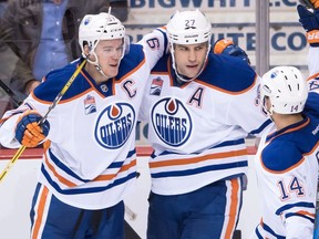 Edmonton Oilers' Connor McDavid, from left to right, Milan Lucic and Jordan Eberle celebrate Lucic's empty net goal against the Vancouver Canucks during the third period of an NHL hockey game in Vancouver, B.C., on Friday October 28, 2016.
