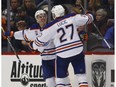 Edmonton Oilers center Connor McDavid, back celebrates his goal with left wing Milan Lucic during the third period of an NHL hockey game against the Colorado Avalanche on Wednesday, Nov. 23, 2016, in Denver.
