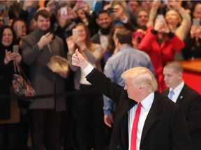 U.S. president-elect Donald Trump gives a thumbs up to the crowd as he walks through the lobby of the New York Times following a meeting with editors at the paper on Nov. 22, 2016 in New York City.