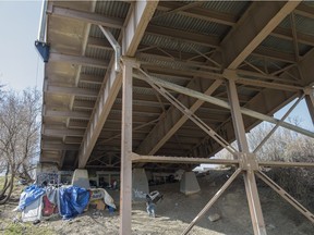 A man walks up to a homeless camp underneath a bridge in Edmonton.