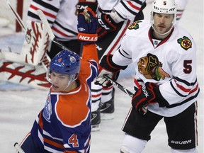 Edmonton Oilers forward Taylor Hall celebrates his hat-trick against the Chicago Blackhawks, from left, Ray Emery, Marian Hossa and Steve Montador during third period action at Rexall Place on Nov. 19, 2011.