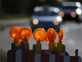 Barricade reflectors catch the early morning light on Saskatchewan Drive in a file photo. A city official says Edmonton is working to craft a policy demanding more thought go into paths for cyclists and pedestrians in and around construction zones.