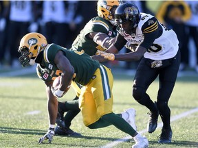 Edmonton Eskimos' Kenny Ladler (37) scrambles away after intercepting a pass as Hamilton Tiger Cats' Terrence Toliver (80) gives chase during second half CFL playoff action, in Hamilton, Ont., on Sunday, November 13, 2016.