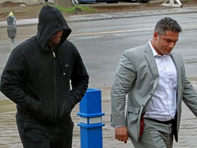 Kalab Abberra Kitil, left, and his lawyer Sam Jomha walk into the Edmonton Police Service headquarters where detectives were waiting for him on June 9, 2014. Kitil was handed an eight-year prison sentence on Nov. 4, 2016 after pleading guilty to manslaughter.