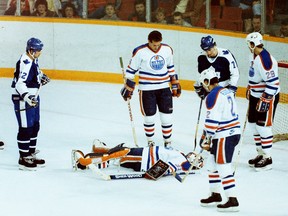 Teammates surround Edmonton Oilers goalie Grant Fuhr after he was hurt during NHL action against the visiting Toronto Maple Leafs on Nov. 3, 1985.