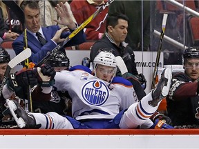 Edmonton Oilers center Connor McDavid ends up over the boards and into the Arizona Coyotes bench during the second period of an NHL hockey game Friday, Nov. 25, 2016, in Glendale, Ariz.