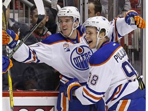 Edmonton Oilers center Connor McDavid, left, celebrates his goal against the Arizona Coyotes with right wing Jesse Puljujarvi (98) during the first period of an NHL hockey game Friday, Nov. 25, 2016, in Glendale, Ariz.