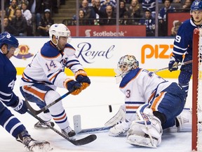 Edmonton Oilers goalie Cam Talbot (33) makes a save against Toronto Maple Leafs centre Tyler Bozak (42) as Oilers right wing Jordan Eberle (14) clears the puck during second period NHL hockey action in Toronto on Tuesday, November 1, 2016.