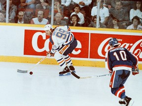 Edmonton Oilers centre Wayne Gretzky skates with the puck ahead of Winnipeg Jets counterpart Dale Hawerchuk during NHL action at Edmonton's Northlands Coliseum in an undated photo.