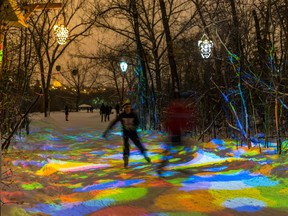 Edmontonians skate through a colourful light installation by artist Dylan Toymaker at the Edmonton Freezeway ice skating ring in Victoria Park in Edmonton.