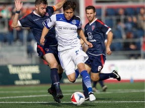 FC Edmonton midfielder Dustin Corea steps by Indy Eleven midfielder Sinisa Ubiparipovic as Dylan Mares looks on in the North American Soccer League semifinal at Carroll Stadium in Indianapolis, Indiana on Saturday, Nov. 5, 2016.