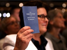 A supporter holds a copy of the U.S. Constitution during a campaign rally in Manchester, New Hampshire, with Democratic presidential nominee former Secretary of State Hillary Clinton at The Armory on Nov. 6, 2016.