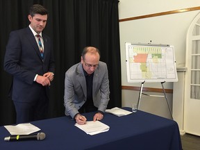 Mayor Don Iveson and Leduc County Mayor John Whaley sign an agreement on annexation in Edmonton on Nov. 30, 2016.