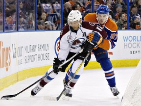 Colorado Avalanche's Jarome Iginla (12) and Edmonton Oilers' Connor McDavid (97) battle for the puck during first period NHL action in Edmonton, Alta., on Sunday March 20, 2016.