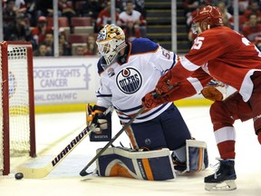 Edmonton Oilers goalie Jonas Gustavsson (50), of Sweden, knocks the puck away from Detroit Red Wings defenseman Mike Green (25) during the second period of an NHL hockey game in Detroit, Sunday, Nov. 6, 2016.