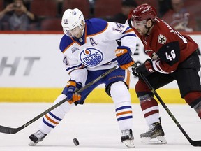 Edmonton Oilers' Jordan Eberle (14) tries to control the puck in front of Arizona Coyotes' Jordan Martinook (48) during the first period of an NHL hockey game, Tuesday, March 22, 2016, in Glendale, Ariz.