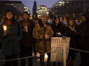 Participants takes part in a candlelight vigil at the Alberta legislature as part of the national day of action against the Kinder Morgan pipeline on Monday, Nov. 21, 2016, in Edmonton.