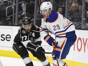 Edmonton Oilers center Leon Draisaitl, right, of Germany, tries to pass the puck while under pressure from Los Angeles Kings center Jeff Carter during the first period of an NHL hockey game, Thursday, Nov. 17, 2016, in Los Angeles.
