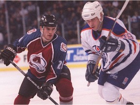 Colorado Avalanche centre Stephane Yelle, left, and Edmonton Oilers centre Doug Weight chase the puck after a faceoff on Dec. 20, 1995, at Edmonton Coliseum.