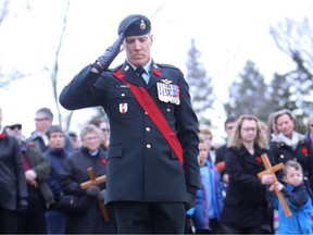 Master Warrant Officer Marco Favasoli places a cross in the ground for fellow Canadian Forces soldier Master Cpl. Erin Doyle, a soldier with the Princess Patricia's 3rd Battalion who died in August 2011 in Afghanistan, during a Remembrance Day Event at the Ainsworth Dyer Bridge in Edmonton's Rundle Park, Nov. 11, 2016.