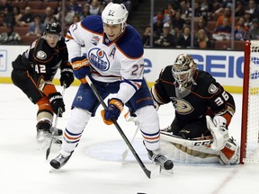 Edmonton Oilers left wing Milan Lucic (27) controls the puck in front of Anaheim Ducks goalie John Gibson (36) and defenseman Josh Manson (42) during the first period of an NHL hockey game in Anaheim, Calif., Tuesday, Nov. 15, 2016.