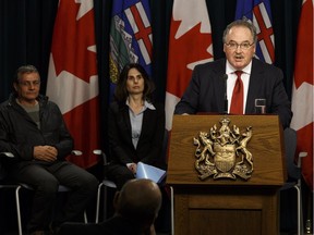 Transportation Minister Brian Mason (right) speaks about amendments to the Traffic Safety Act requiring all-terrain vehicle users wear a helmet on public lands during a press conference at the Alberta legislature on Monday, Nov. 28, 2016.