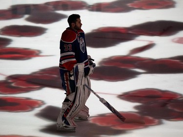 Poppies are projected on to the ice around Edmonton Oilers' goalie Cam Talbot (33) as part of Remembrance Day ceremonies prior to the start of the game against he Dallas Stars at Rogers Place, in Edmonton on Friday Nov. 10, 2016.
